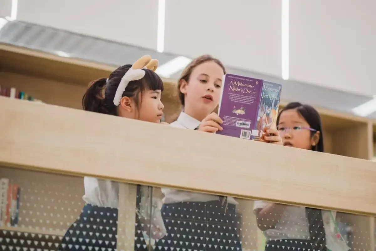 Three female pupils studying at Wellington College International Tianjin, China, read an English book named ‘A Midsummer Night’s Dream’ together. 