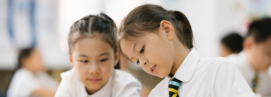 Primary School students put their heads together and learn in class through the English and Chinese curriculum in an international school